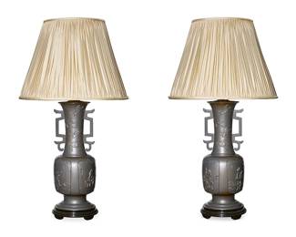 335
A pair of Japanese-style bronze lamps
20th century
Each with figures in the panels and birds on the necks, mounted as a single-light table lamp, on black lacquered circular foot, surmounted by a pleated fabric shade, electrified
2 pieces
Each lamp without harp or shade: 24" H x 8" Dia.; Each shade: 13" H x 18.5" Dia.
Estimate: $500 - $700