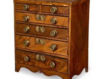 306
A miniature Federal-style veneered wood chest
19th century
The six-drawer chest with gold-toned metal hardware and pulls, the bottom drawer with inner compartments, on ogee bracket feet
14" H x 12" W x 8" D
Estimate: $200 - $300