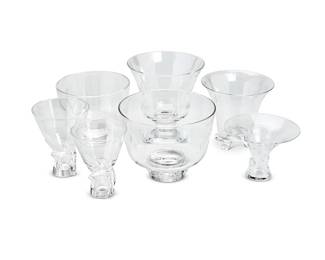 136
A group of Steuben glass bowls and vases
20th century
Each with etched Steuben script mark; two personalized with inscriptions
Comprising a footed bowl, a footed bowl with applied prunts to the foot, a flared and footed vase with four feet, two footed vases with applied twist decorations to the feet, a flared bowl with applied 'thumbprint' decoration, and a flared and footed vase
7 pieces
Largest: 7" H x 9" Dia.; Smallest: 5" H x 7.125" Dia.
Estimate: $800 - $1,200