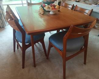 Teak table with extending leaves and 8 chairs.