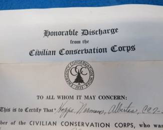 Lot 15. 1940 CCC (Civilian Conservation Corps) discharge papers, WW2 ration books with and without stamps, and unused US Army postcards.