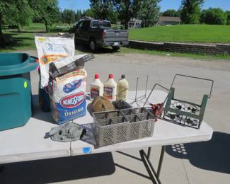 Lot 174. Charcoal and lighter fluid, tabletop grinding stone, resin crocodile lawn sprinkler, and more with tote
