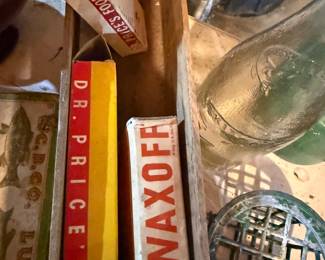 Antique collectibles lot: vintage wooden box with old Dr. Price's and Waxoff product boxes, plus a glass bottle and metal floral frog.