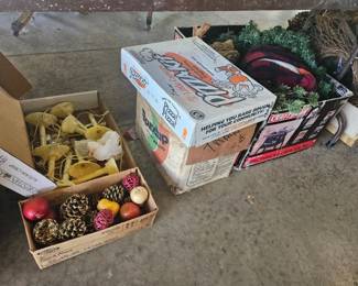 Cardboard boxes of assorted items including a crate of plastic faux fruit and vegetables and several vintage board games.
