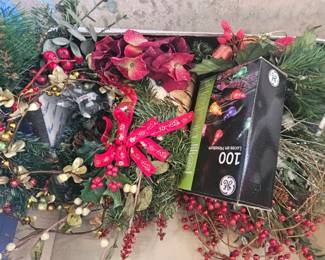 Artificial holiday greenery and red berry picks along with a box of GE 100 count multi-color Christmas lights.