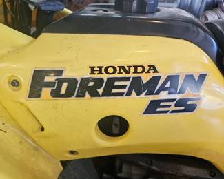 Close‑up view of the yellow Honda Foreman ES logo on the body panel of the ATV.