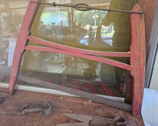 Vintage red-painted wood farm tool frame with metal hardware, possibly part of a cultivator or implement.