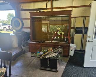 Display area featuring a glass-front cabinet with decorative items, a wooden chair, and various small furnishings and decor pieces.