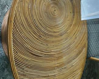 Top view of a circular woven wood table top with tight concentric swirl pattern, possibly rattan or bent plywood.