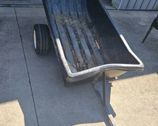 Vintage metal wheelbarrow or cart with a single front wheel and two support legs, ideal for garden or farm use.