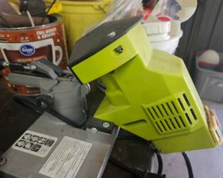Bright green electric wood chipper or shredder machine with black base, compact design.