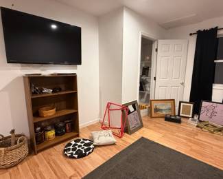 Bookshelf, 50" tv, office supplies, framed prints and open frames, grey rug