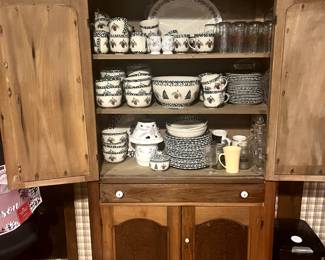 Large antique hutch, designer holiday dishes. 