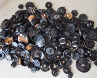 Black glass and jet antique buttons. There are bins of buttons and beads.