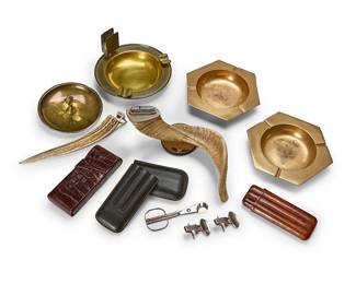 1142
A group of smoking articles
Late 20th century
Horn labeled: Made in Italy / Gucci; cigar rest clips marked: S. T. Dupont / Paris
Comprising a Gucci horn table lighter (personalized), another horn lighter, three brass ashtrays, three leather cigar cases, two chromed metal cigar rest clips, and a cigar cutter
11 pieces
Larger horn lighter: 5.25" H x 10.5" W x 7.5" D; Largest ashtray: 4.5" H x 8" Dia.
Estimate: $100 - $200