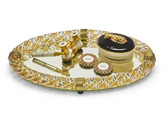 1219
A group of miscellaneous glass items
Early 20th/early 21st century
Opera marked: Lemaire / Fab / Paris; frames marked for Jay Strongwater
Comprising a Mike & Ally gilt-metal and glass box surmounted by a large cat, an oval mirrored tray with a twisted glass wrapped rim, two Jay Strongwater clip frames, and a pair of French gilt-metal and mother of pearl opera glasses
5 pieces
Tray: 2" H x 16" W x 10.5" D
Estimate: $300 - $500