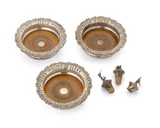 1358
A set of three English sterling silver wine coasters and stoppers
19th/20th century
Coasters marked for sterling, Sheffield, 1828, and maker: TB & Co.; stoppers marked for sterling, Birmingham, 1992, and maker: AJP
Comprising three George IV coasters with scrolled foliate motif rims and wood bases, and three later sterling silver and cork wine stoppers
6 pieces
Each coaster: 2" H x 7" Dia.; Each stopper: 3.25" H approximately
Estimate: $300 - $400