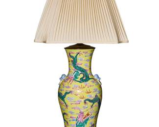 1243
A Chinese Famille Jaune porcelain table lamp
20th century
The baluster-form vase with dragons on a yellow ground, the shoulders with two ringed lion mask handles, mounted on a carved wood foot, with a pleated fabric shade, electrified
Overall: 34" H x 17.5" W x 17.5" D; Vase 18" H x 8.5" Dia.
Estimate: $200 - $300