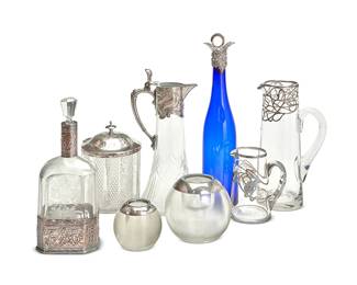 1091
An assorted group of glass vessels
20th/early 21st century
Some variously marked for maker; match strikes with indistinct English hallmarks to silver mounts
Comprising two English sterling silver-mounted glass match strikes (Larger: 4.75" H x 5.75" Dia.), a biscuit jar with a silver-plated lid (7" H x 6" Dia.), an Art Nouveau-style silver plate-mounted glass ewer (11.75" H x 5.125" D), two pitchers with applied glass handles and Art Nouveau-style silver resist decoration (Taller: 10" H), a silver-mounted cobalt blue glass decanter with stopper (14.5" H), a silver-mounted clear and frosted glass decanter with stopper (10.75" H), and a pair of Alvin sterling silver-mounted glass cordials (Taller: 3.5" H)
10 pieces
Estimate: $300 - $500