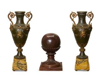 1167
A pair of Victorian bronze two-handled urns
Late 19th/20th century
Each with masks, swags, and acanthus decoration, raised on a yellow marble plinth base, together with a patinated metal newel post
3 pieces
Each vase: 17.5" H x 5.5" Dia.; Newel: 10.75" H x 7" W x 7" D
Estimate: $200 - $300