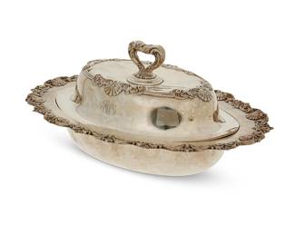 1003
A Whiting sterling silver entrée dish and cover
1908; New York City, NY
Dish marked for Whiting, for sterling, and numbered: 5010; cover appears unmarked, but tested for sterling
Of oval form, with scroll and shell decoration, personalized
5.5" H x 12.25" W x 9" D
28.6 oz. troy approximately
Estimate: $400 - $600