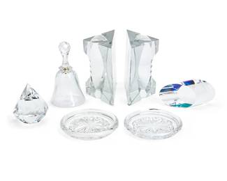 1213
A group of Contemporary glass desk accessories
Late 20th century
Tiffany with stencil mark: Tiffany & Co.; other paperweight indistinctly inscribed; coasters, bookends, and bell with Baccarat factory stencil marks
Comprising a Tiffany & Co. diamond-form paperweight (3.75" H x 3.5" Dia.) and a group of Baccarat glass including a dinner bell (6.5" H x 3.5" Dia.), a pair of book ends, and a pair of coasters, together with a paperweight from an unknown maker
7 pieces
Estimate: $200 - $300