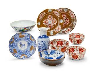 1179
A group of East Asian porcelain vessels
19th/20th century
One bowl bearing an apocryphal reign mark to underside; three red bowls with blue underglaze mark
Comprising a Chinese blue and white vase decorated with a landscape scene, a Chinese shallow bowl, two Chinese plates with iron red and white medallions on a brown ground, a graduated set of three rust, white, and blue bowls, a blue and white bowl, and a blue, white, and gilt porcelain scalloped dish
9 pieces
Vase: 9.5" H; Brown plate: 9" Dia., Blue plate: 8.5" Dia.
Estimate: $200 - $300