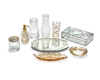1079
A group of Contemporary glass table items
20th century
Some variously marked for maker
Comprising a set of three Labrazel gilt and cut glass bathroom accessories including a shallow round dish, a tumbler, and a soap dispenser, a Heisey gilt-decorated amber glass leaf-form dish, and five other vanity items including a covered box with enameled lid
9 pieces
Soap dispenser: 6" H x 3.25" Dia.; Amber dish: 1.5" H x 10.25" W x 4" D
Estimate: $100 - $150