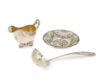 1007
Three German silver table items
19th/early 20th century
Sauce boat marked: Sy & Wagner / Berlin / 875; also with inscribed armorial: In Der Treue Fest; pierced bowl with German hallmarks, marked for 800, and maker: GR; ladle with German hallmarks and marked for 800
Comprising an .875 silver sauce boat with a gilt interior, on an ivy and twig-form foot (5.25" H x 10" W x 4.25" D), an .800 silver pierced bowl depicting a central scene of a couple and a dog (2" H x 8.5" Dia.), and an .800 silver ladle (13.5" L)
3 pieces
Total weight: 33.2 oz. troy approximately
Estimate: $400 - $600