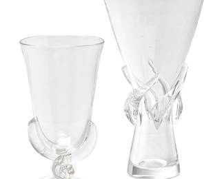 1045
Two Steuben glass vases
20th century
Each with etched Steuben script mark
Comprising a vase designed by George Thompson with applied twist decorations at the waist, and a flared and footed vase with applied 'fingers' extending up from the round foot
2 pieces
Taller: 11.5" H x 6.5" Dia.; Shorter: 9" H x 5" Dia.
Estimate: $200 - $300