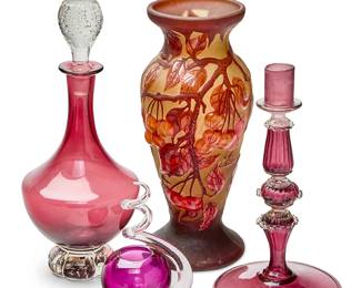 1186
An assembled group of glass table items
Mid/late 20th century
Romanian with spurious marks in the cameo: Galle / tip; one vase signed indistinctly
Comprising a Romanian reproduction Gallé-style vase depicting stone fruit hanging from branches (12" H x 5.5" Dia.), an amethyst and clear glass candlestick (10" H x 6" Dia.), a small amethyst and clear glass 'twist' vase (6" H x 3.25" Dia.), and an Irving W. Rice & Co. cranberry and clear glass decanter and stopper (13" H x 6" Dia.)
4 pieces
Estimate: $100 - $200