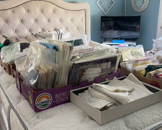 Underneath all those tablecloths is a great pillowtop queen size bed with upholstered headboard, However, don't overlook the linens. This house has numerous flats of great clean linens including several new in the package.