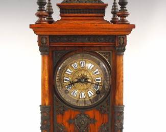 A late 19th century Ansonia Cabinet Antique model table clock.  8-day time and strike movement with French Sash and shield shaped porcelain markers with Roman numerals.  Oak case with extensive cast brass appliques featured a molded top with five turned finials around a brass dome, molded crown with cast frieze above cast brass panels on front and sides flanked by turned columns on a molded base.  Old, cleaned finish with minor wear, movement dirty, running momentarily when cataloged.  19 1/2" high.  ESTIMATE $600-800