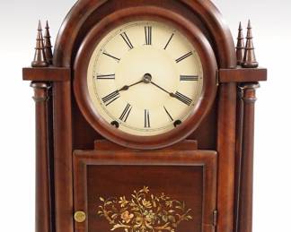 A 19th century E C Brewster Gothic shelf clock.  8-day time and strike movement with painted metal dial and Roman numerals.  Mahogany case with "Onion" top above a single door with circular dial glass and lower panel with painted floral detail flanked by four turned columns with tapered finals on a simple plinth base.  Older refinishing with minor wear, minor dial wear, running when cataloged.  19 1/4" high.  ESTIMATE $400-600