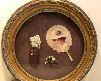 Round gold framed shadowbox of Victorian ladies' items