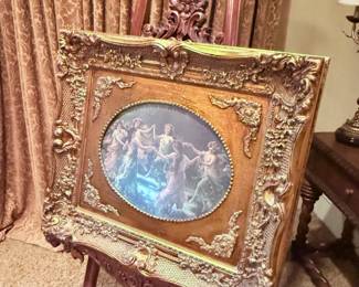 Dark wood decorative easel with ornate gold framed reproduction painting of dancing cherubs