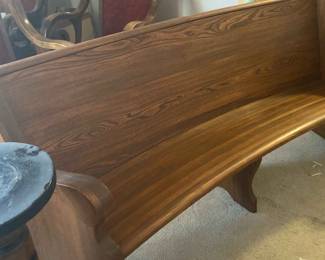 An Old Curved Church Pew And An Old Pillar Type Stand