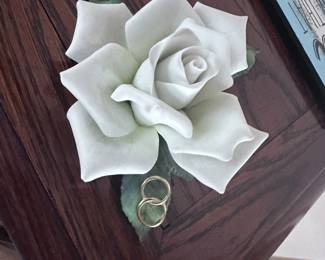 "The Anniversary Rose" by Roman, Inc. This piece features a white rose with two wedding bands intertwined at its base. 