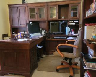 Home office furniture set includes five drawer desk, computer alcove, storage cabinets, floor mat, and chair.
