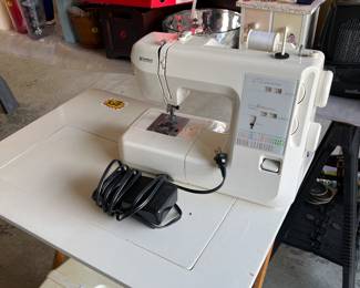 Kenmore sewing machine with case, and a sewing machine table.