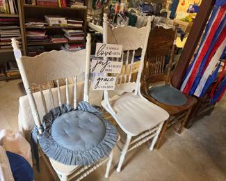 Probably a half dozen or more random single wooden chairs