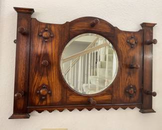 Wall mirror with round beveled center, four side pegs and four pegs around mirror, needs tightening up but is well attached to the wall