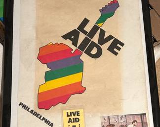 Framed Live Aid banner, backstage pass, and photo showing Eric Clapton at show with banner in background