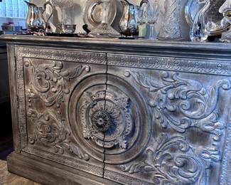 Hooker Sideboard with ornate carvings. Display of Waterford, etched glass, and Silver collections. Michael Aram gold tea strainer.