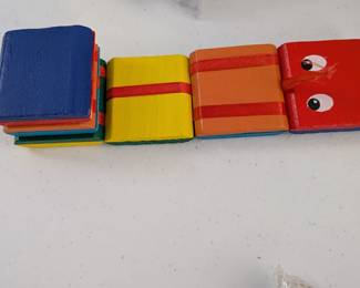 A delightful segmented wooden toy in bright colors, designed to flex and move. Great for imaginative play, developing fine motor skills, and exploring movement.