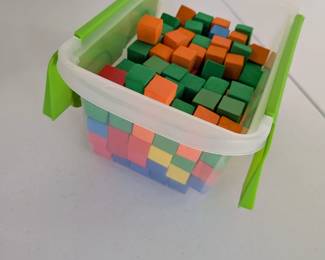 Large Set of Colorful Foam Building Blocks in Storage Container: A substantial collection of vibrant, uniformly small sized building blocks, ideal for early childhood learning and play. Perfect for creative construction, teaching counting and patterning, fostering spatial reasoning, and developing fine motor skills. Comes neatly stored in a clear container with a secure lid. A versatile addition to any classroom, playroom, or homeschool setting.