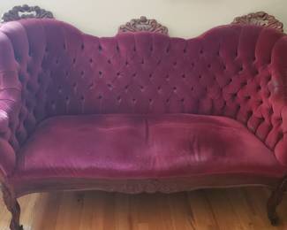 Tufted red velvet sofa.