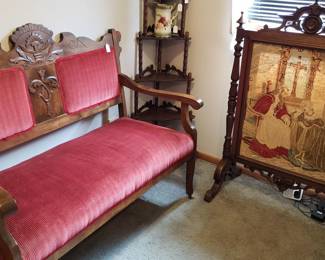 Red velvet settee and ornately carved fireplace screen.