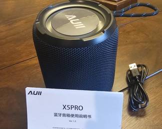 AUII X5PRO portable Bluetooth speaker. It's designed for wireless audio playback, typically connecting to smartphones, tablets, or computers via Bluetooth. It includes a carrying loop, charging cable (USB), and user manual. The device is compact, portable, and suitable for outdoor and indoor listening.