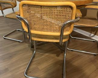 Mid century Cesca style chrome and wood table with chrome and cane chairs. Measures 30" H x 42" diameter. Chairs measure 32"tall at back x 23" widest point. Image 6. Price $850.